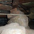 A crawl space support consisting of a rock and wood shimming in a Alexandria home
